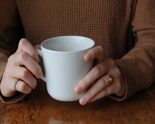 Close up of hands holding a warm cup of tea